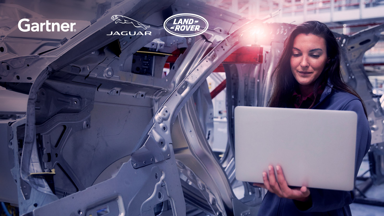 图形:高德纳捷豹路虎的标志在一个妇女的形象与笔记本电脑在汽车制造厂工作